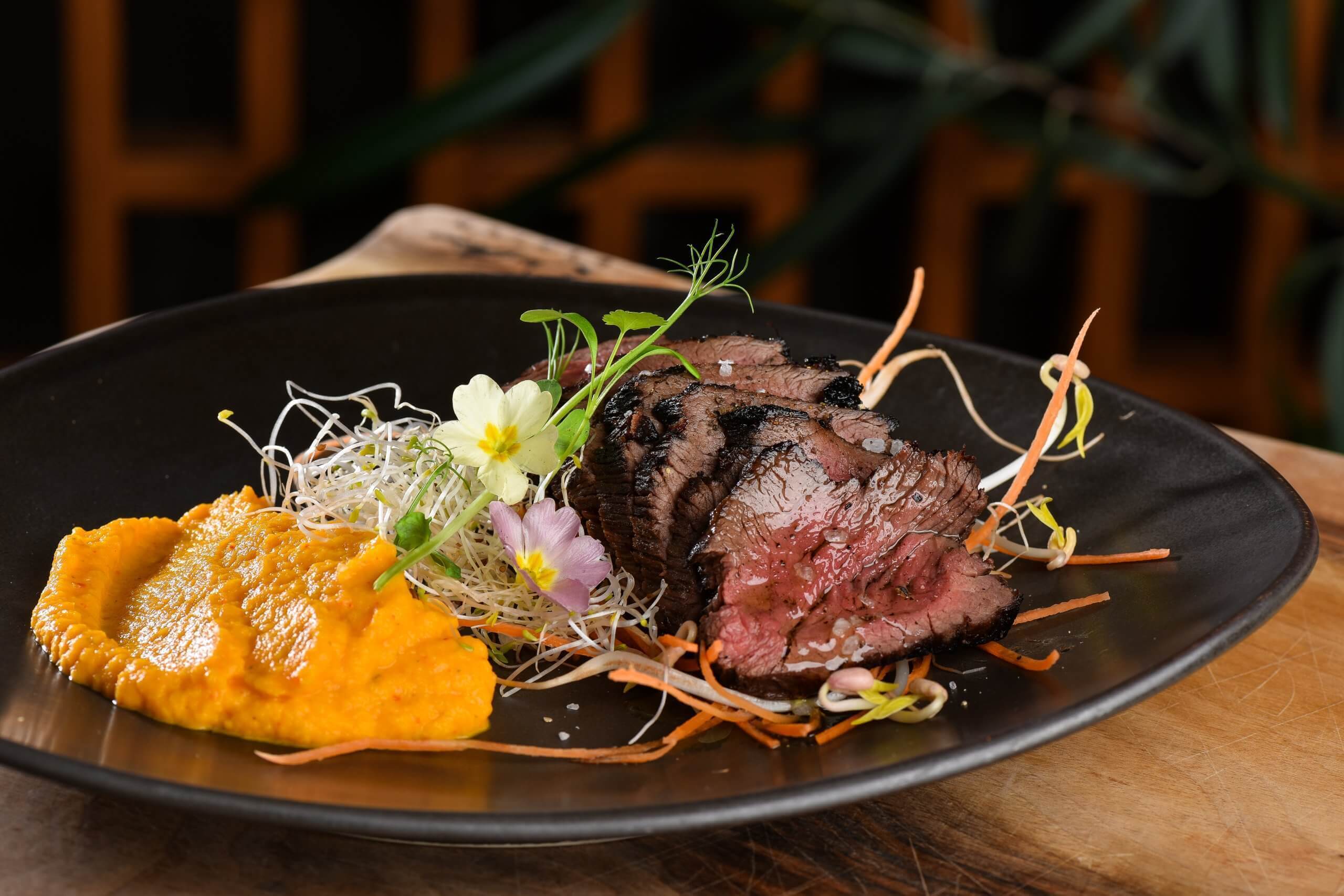 Viande grillé avec de la purée sur un plat noir